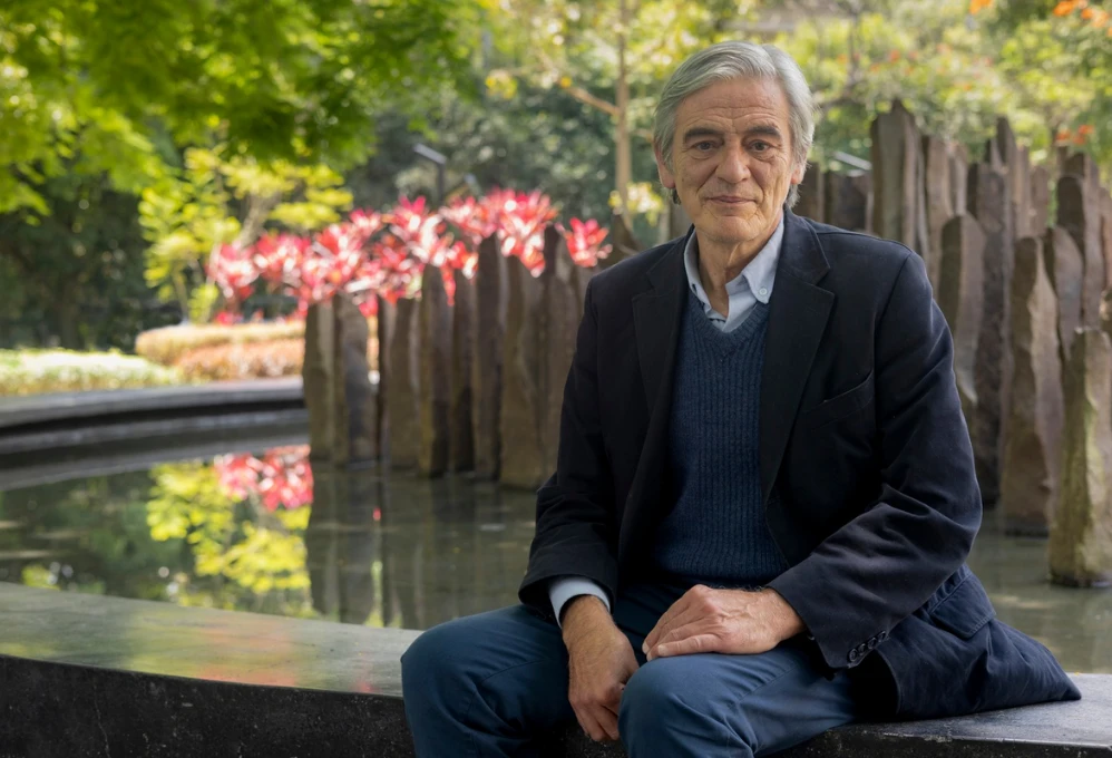 Federico Andreu Guzmán se encuentra sentado junto a una fuente en la Universidad de Antioquia-