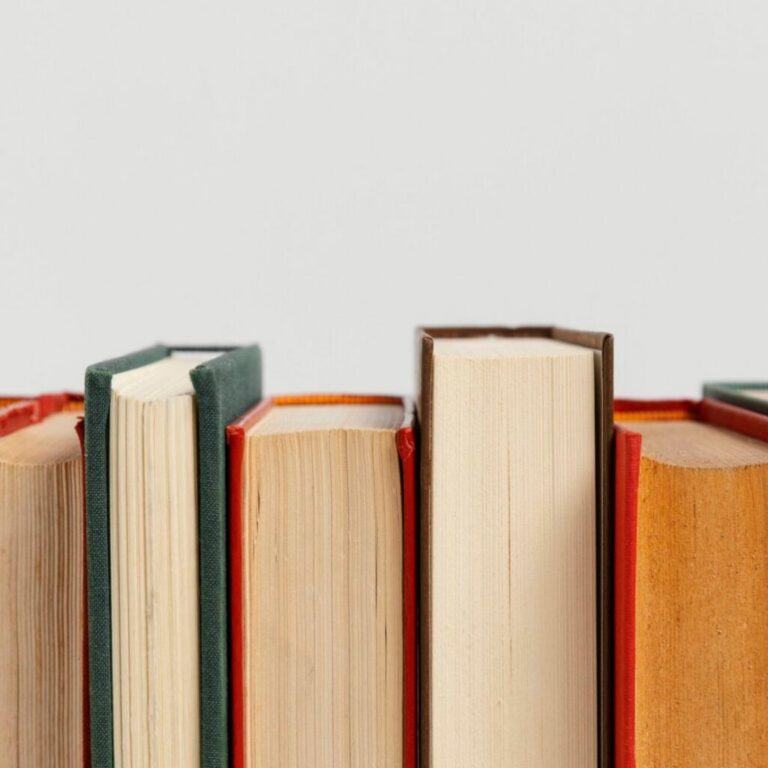 Fila de libros de tapa dura vistos de canto sobre fondo claro